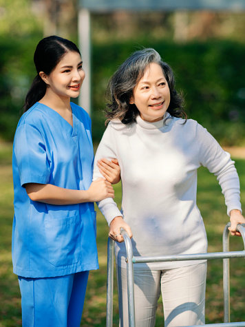 Caregiver helping woman with her walker.