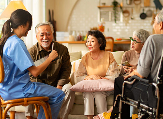 Group of elderly listening to young nurse.