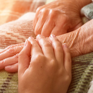 Nurse in hospice hugs elderly woman for comfort