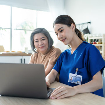 Nurse and woman looking at the laptop.