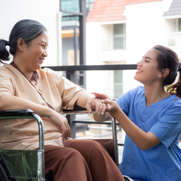 Woman in wheelchair with nurse.