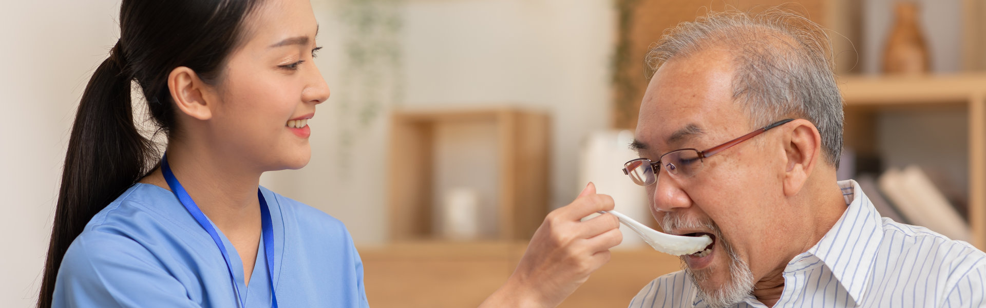 Nurse feeding breakfast to man.