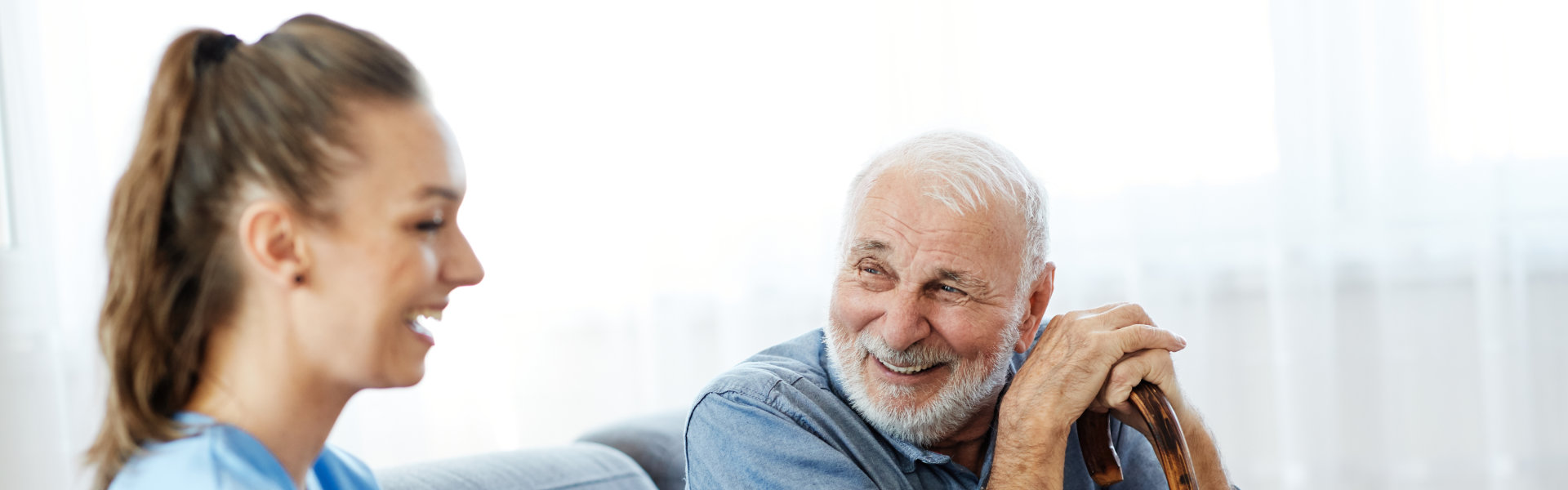 Young nurse happy talking with elderly man.