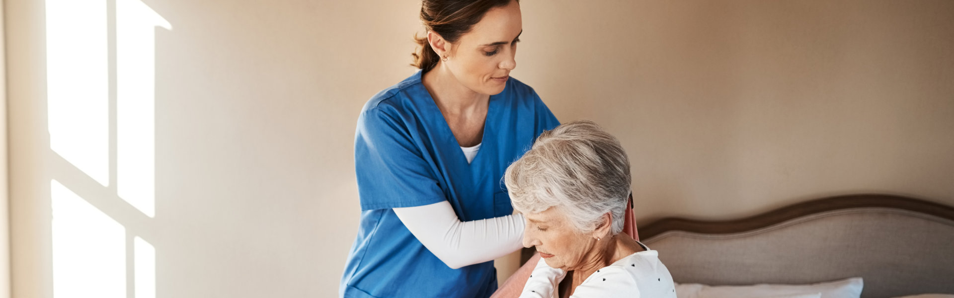 Nurse helps woman to dress.