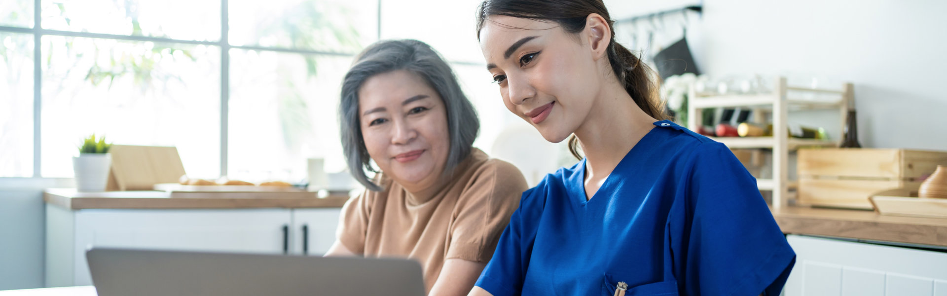 Nurse and woman looking at the laptop.