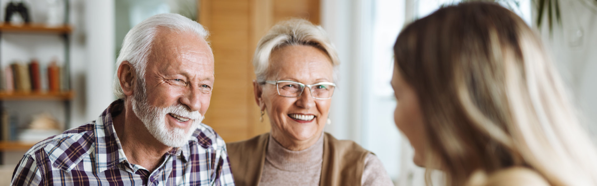 Two elderly smiling with nurse.