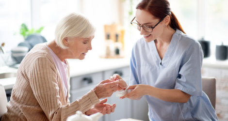 Nurse giving medicine to woman.